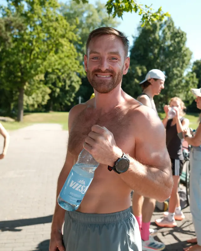 Timon Kukwa lacht nach dem Training, eine Wasserflasche in der Hand