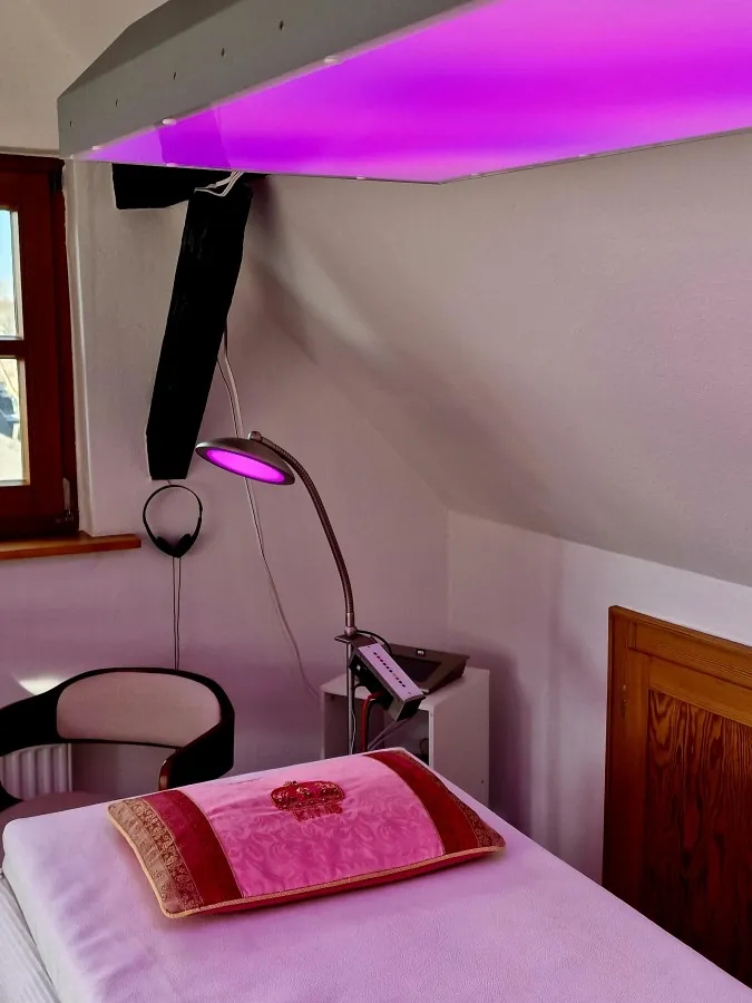 Behandlungsliege unter violettem Licht im Kompetenz Center Limburg