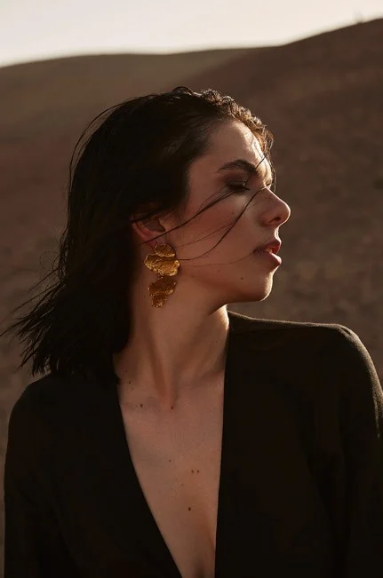 Sophia Elpel im Profil, mit goldenem Ohrring im Abendlicht einer Wüstenlandschaft